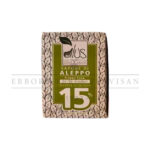 Close-up of Sapone di Aleppo 15% handmade soap. Green and beige packaging with olive leaf design. Natural skincare product.